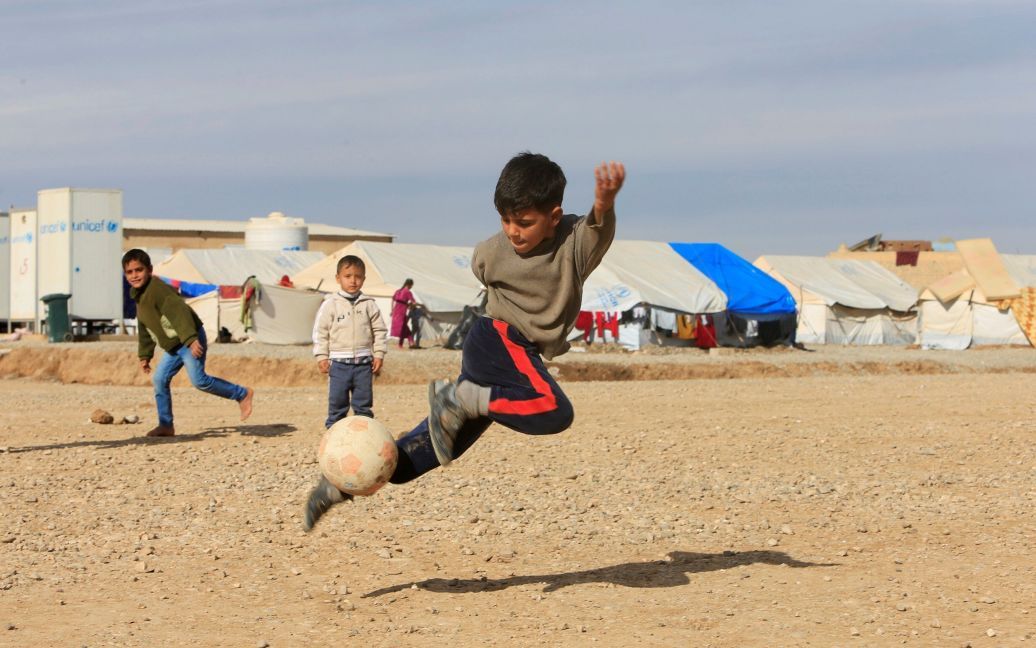 Перемещены иракские дети, которые сбежали из захваченного боевиками &ldquo;Исламского государства&rdquo; Мосула, играют в футбол в лагере Хазер в Ираке. / © Reuters