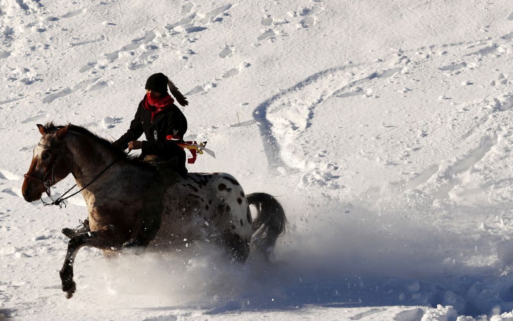 Молодой Индеец едет на лошади по снегу возле лагеря коренных жителей Америки, которые протестуют против планов проложить трубопровод рядом с индейской резервацией в Северной Дакоте. / © Reuters