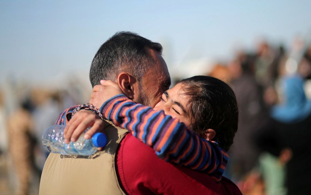 Чоловік, який втік із захопленого бойовиками &ldquo;ІД&rdquo; Мосула, обіймає свою доньку під час їхньої першої зустрічі після втечі з міста, після прибуття батька в табір Хазер, Ірак. / © Reuters
