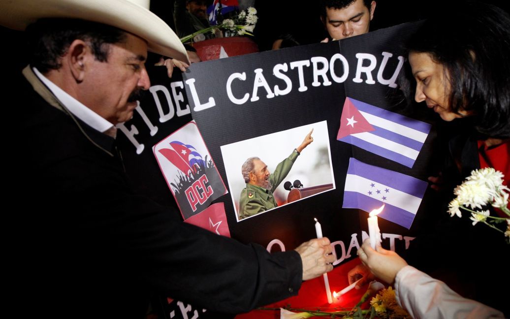 Экс-президент Гондураса Мануэль Зелая ставит свечу / © Reuters