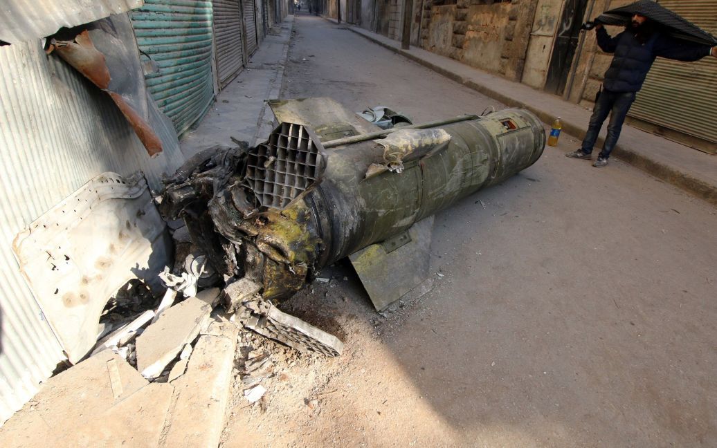 Людина оглядає ракету, що не розірвалася, в утримуваного повстанцями районі Аль-Квартеджи в Алеппо, Сирія. / © Reuters