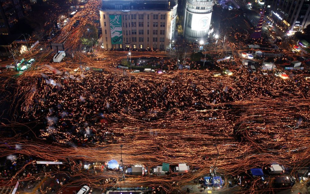 Місцеві жителі тримають свічки під час мітингу проти підозрюваної у корупції президента Південної Кореї Пак Кин Хе на головній вулиці в Сеулі, Південна Корея. На акцію протесту вийшли 1,3 млн людей. / © Reuters