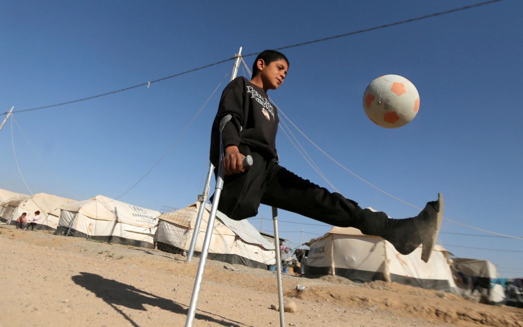 13-летний перемещен иракский мальчик Джасим Абдуллах Джасим, который потерял ногу в результате воздушного удара в Байджи, играет в футбол в лагере на окраине города Эрбиль, Ирак. / © Reuters