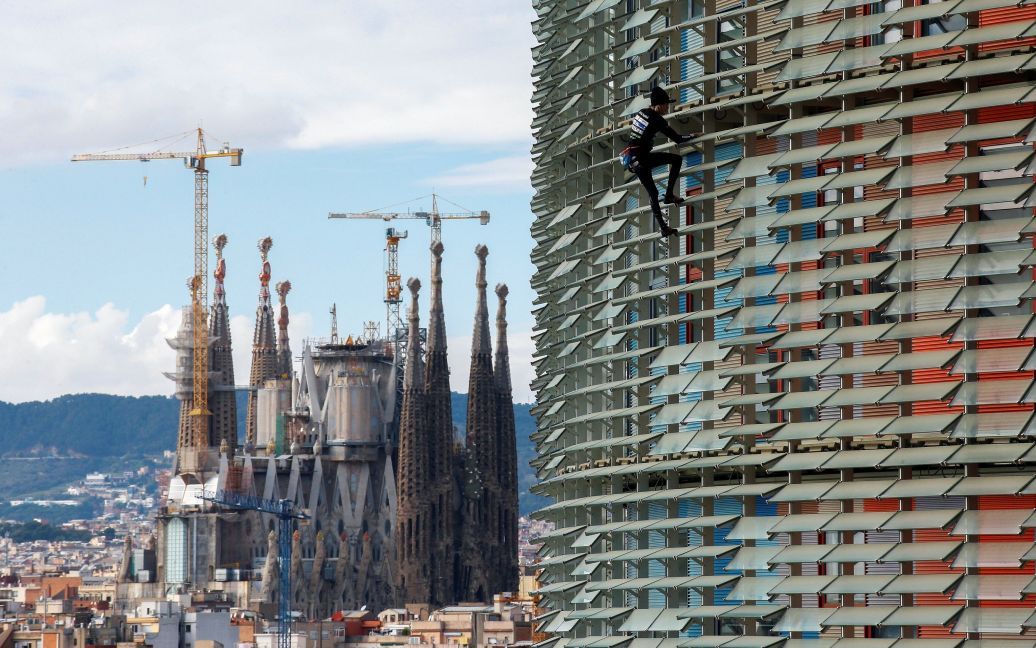 Французький альпініст Ален Робер, відомий також як "Французька людина-павук", підкорює 38-поверховий хмарочос Torre Agbar поруч із собором Саграда Фамілія в Барселоні, Іспанія. / © Reuters