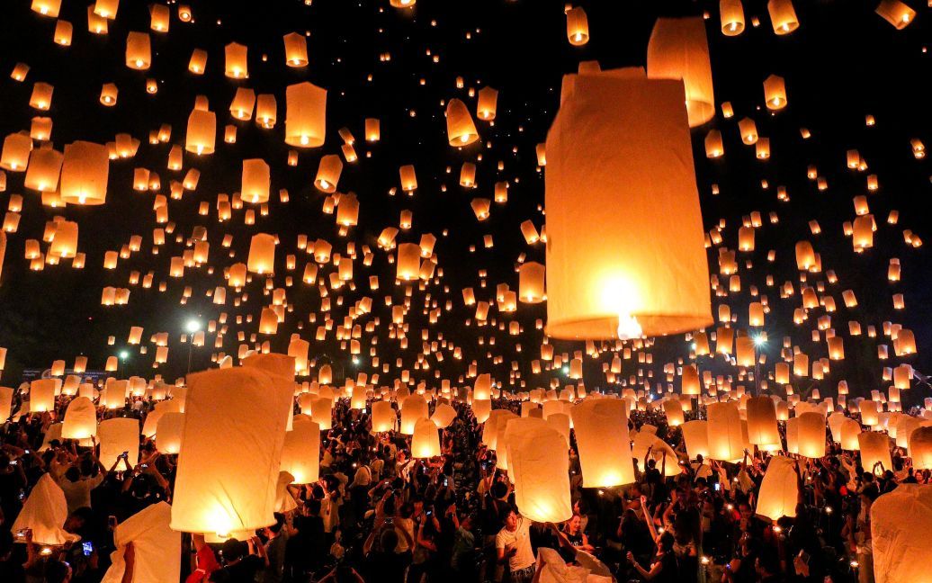 Люди запускают небесные фонарики во время фестиваля Йи Пенг в городе Чиангмай, Таиланд. / © Reuters