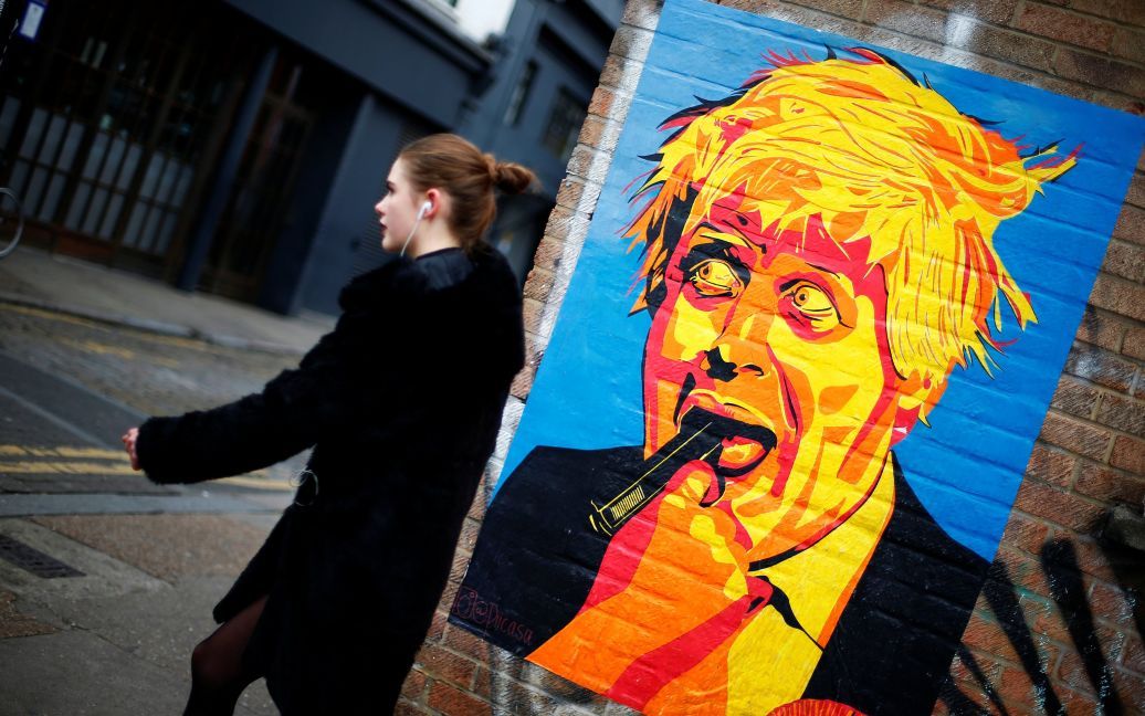 Жінка проходить повз карикатуру міністра закордонних справ Великобританії Бориса Джонсона в східному Лондоні, Великобританія. / © Reuters