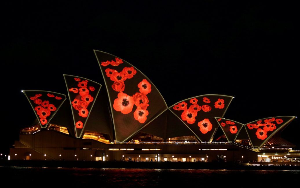 Паруса Сиднейского оперного театра зажигаются маками ко Дню памяти в честь окончания Первой мировой войны. / © Reuters