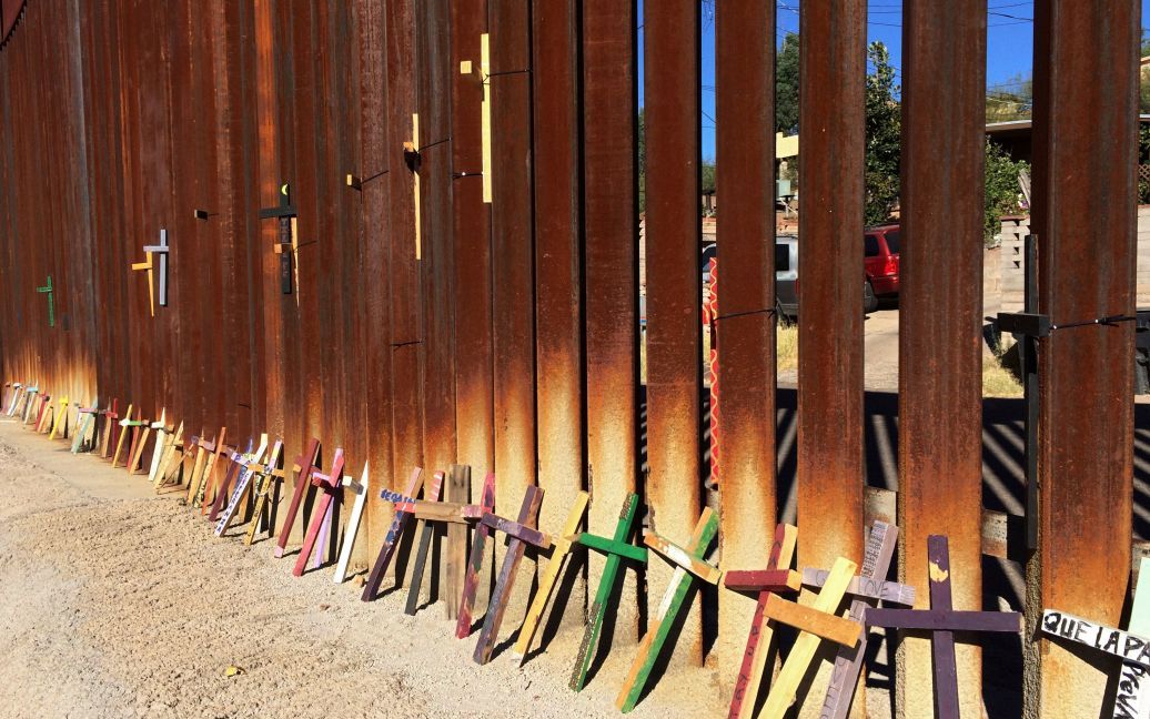 Деревянные кресты в память о мигрантах, которые умерли, пересекая границу с США, стоят рядом с пограничным забором между Мексикой и США. / © Reuters