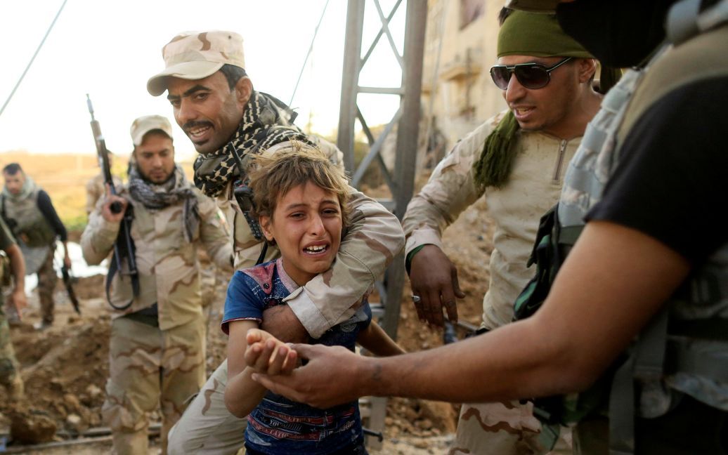 Хлопчик плаче у той час як іракські солдати допомагають йому вийти за лінію фронту під час бою з &ldquo;Ісламською державою&rdquo; в районі Інтісар у східній частині Мосула, Ірак. / © Reuters