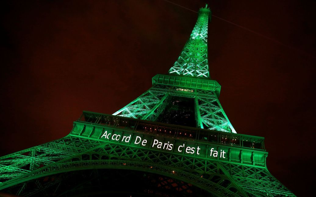Ейфелева вежа горить зеленим кольором з написом "Паризька хартія виконується", відзначаючи першу річницю ухвалення Паризької угоди про зміну клімату. / © Reuters