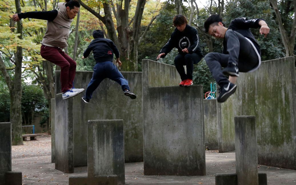Юн Сато (другий зліва), засновник першого інституту з навчання паркуру в Японії, демонструє свою майстерність разом із своїми однодумцями у парку в Токіо. / © Reuters