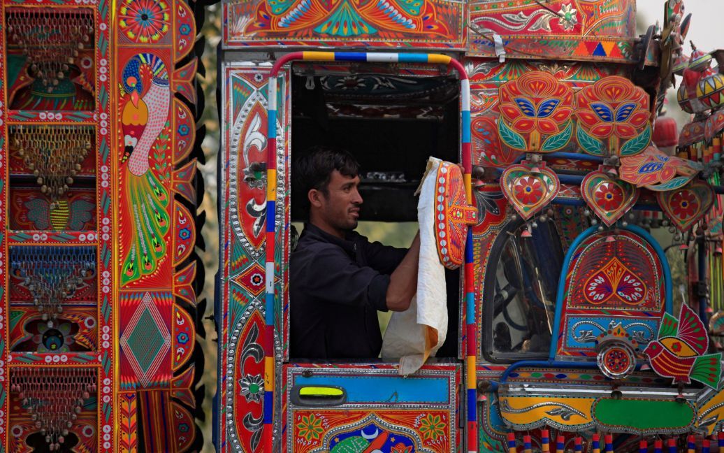 Водій вантажівки очищає дзеркало своєї прикрашеної вантажівки, Пакистан. / © Reuters