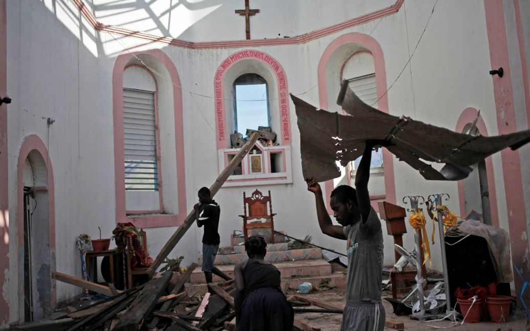 Люди очищают церковь от мусора после урагана Мэтью на Гаити. / © Reuters