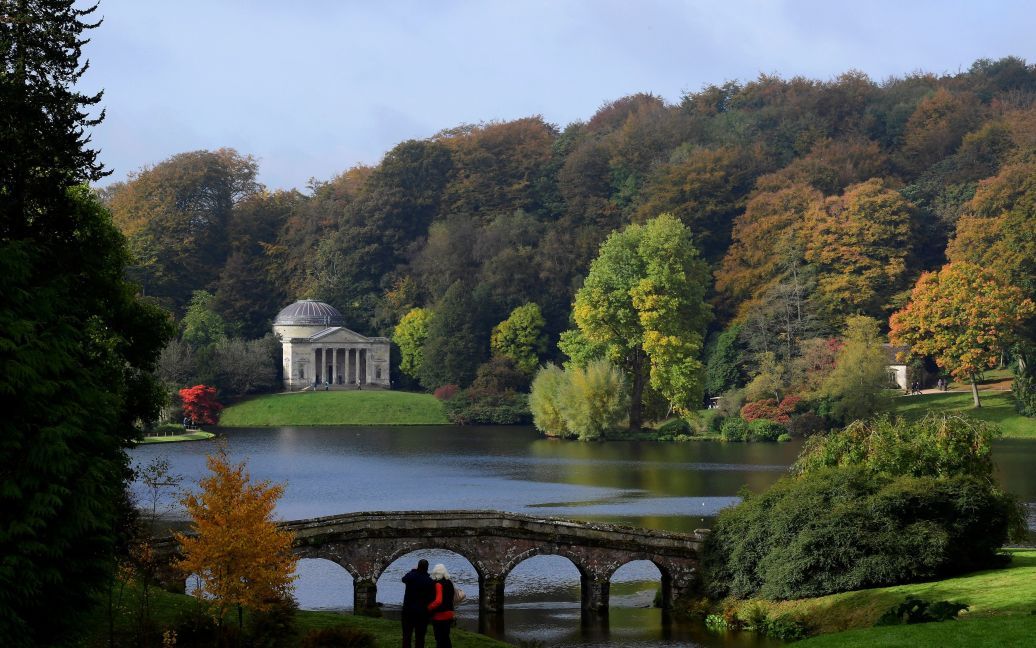 Посетители рассматривают осенние листья и цветы в садах и имения в Стоурхеді на юго-западе Англии. / © Reuters
