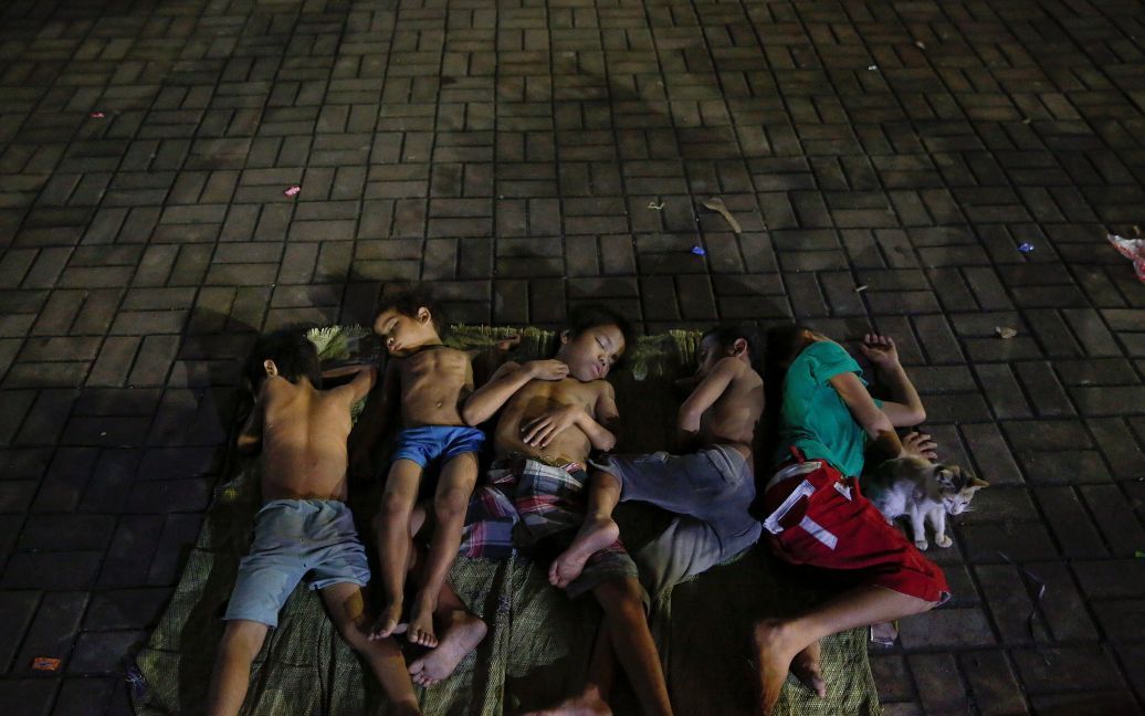 Діти сплять на площі біля церкви в Манілі, Філіппіни. / © Reuters