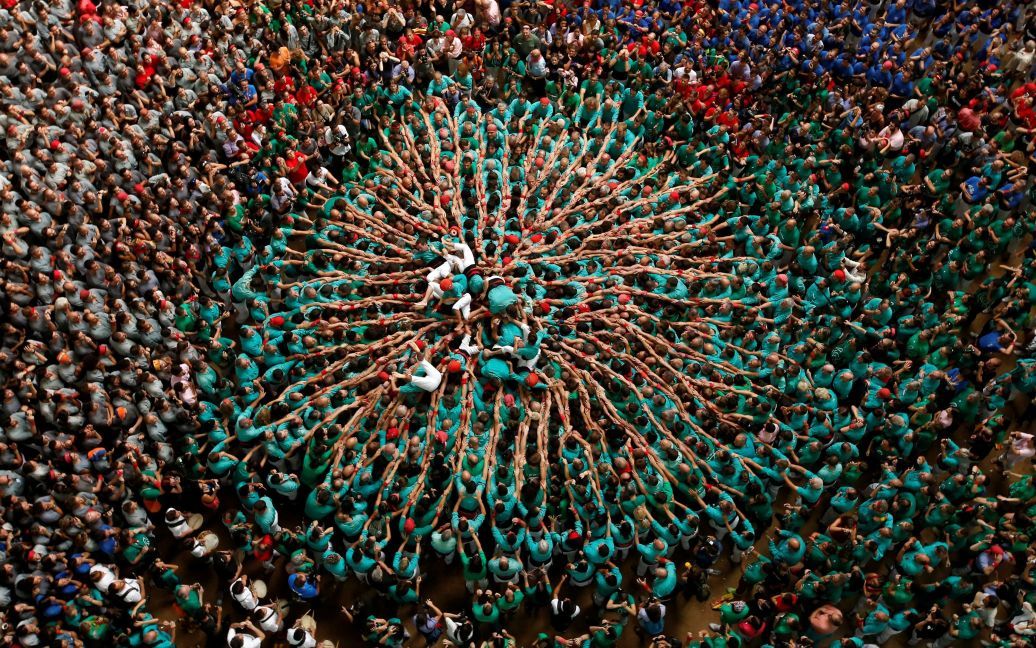 Участники падают после формирования человеческой башни под названием "Кастель" во время соревнований в городе Таррагона, Испания. / © Reuters