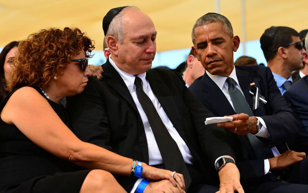 Президент США Барак Обама предлагает платочек Хеми Пересу, сыну бывшего президента Израиля Шимона Переса, во время похорон на кладбище на горе Герцля в Иерусалиме. / © Reuters
