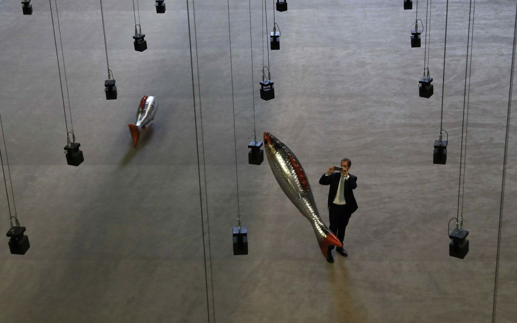 Человек берет картину инсталляции "В любом месте" французского художника Филиппа Парено, в машинном зале Tate Modern в центре Лондона, Великобритания. / © Reuters