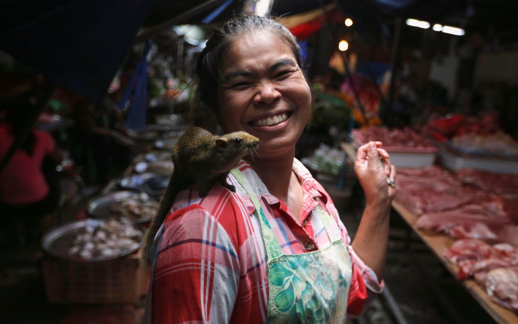 Женщина ходит с белкой на плече на рынке Маеклонг на окраине Бангкока, Таиланд. / © Reuters