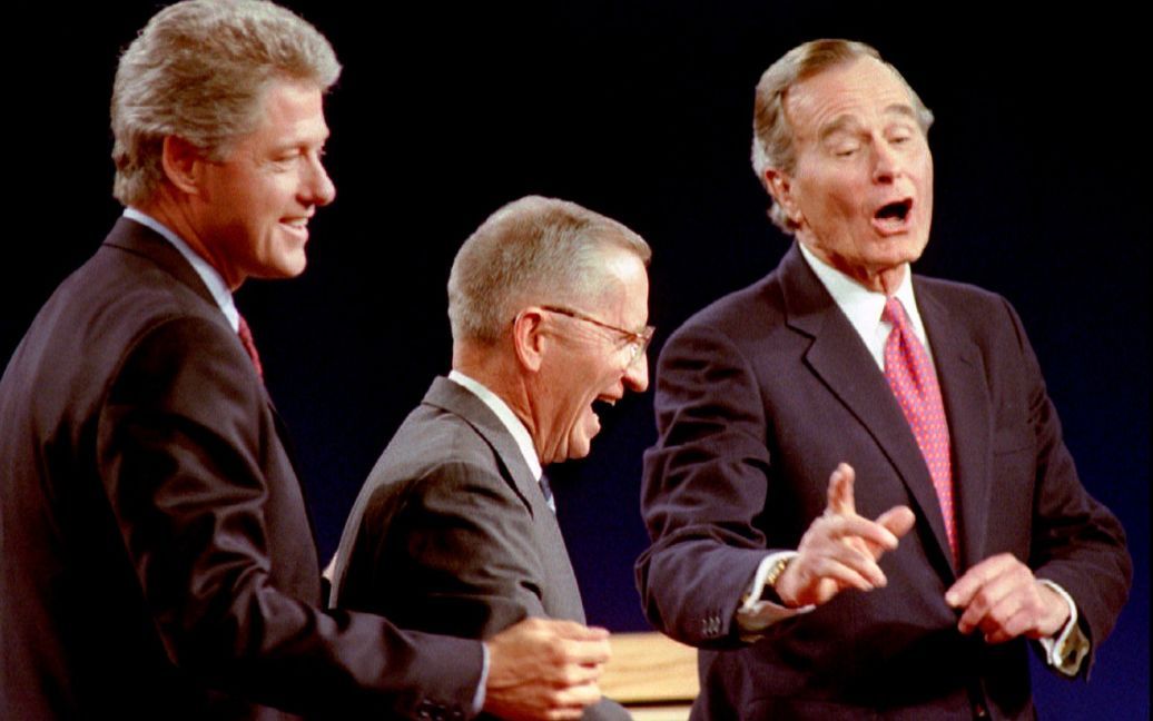 Кандидат в президенты от демократов Билл Клинтон, независимый кандидат Росс Перо и президент Джордж Буш смеются во время дебатов в Ист-Лансинг, штат Мичиган, США, 19 октября 1992 года. / © Reuters
