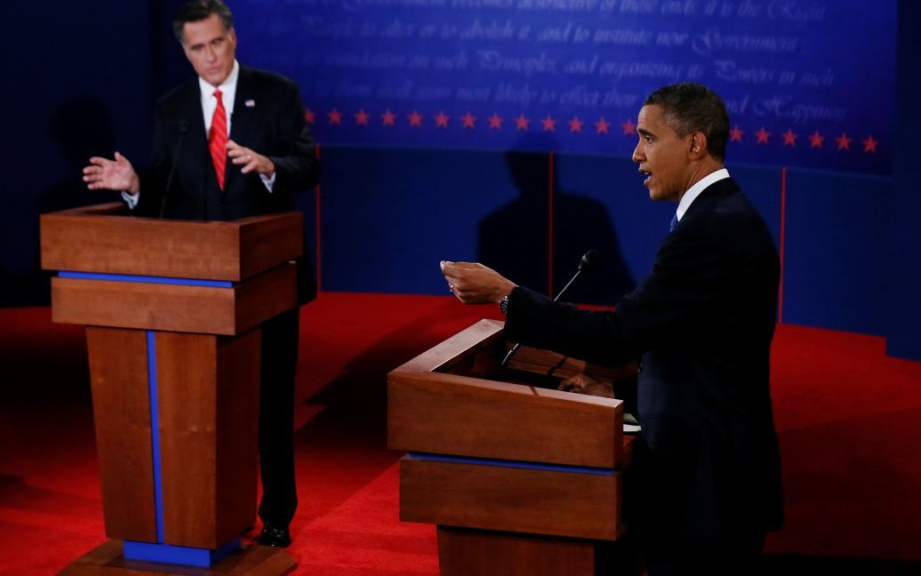 Президент США Барак Обама отвечает на вопрос, в то время как его слушает республиканский кандидат в президенты Митт Ромни во время первых дебатов кампании 2012 года в Денвере, США, 3 октября 2012 года. / © Reuters