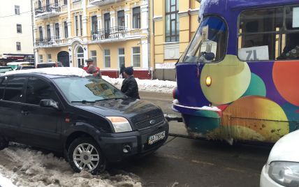 Вузькі вулички Києва стають капканом для трамваїв, бо водії через сніг паркуються ледь не по центру дороги