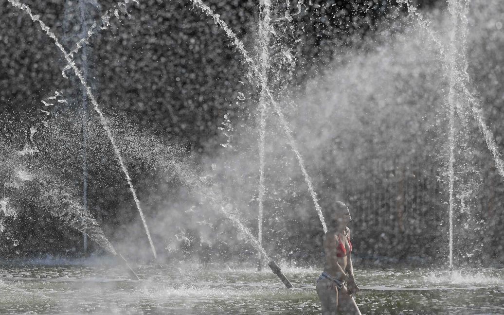 Жінка охолоджується у фонтані у надзвичайно спекотний день у Баттерсі-парку в західній частині Лондона, Великобританія. / © Reuters