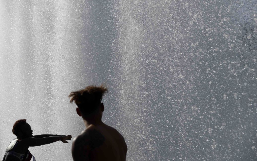 Люди охолоджуються біля фонтану в парку Баттерсі у спекотний день у Лондоні, Великобританія. / © Reuters