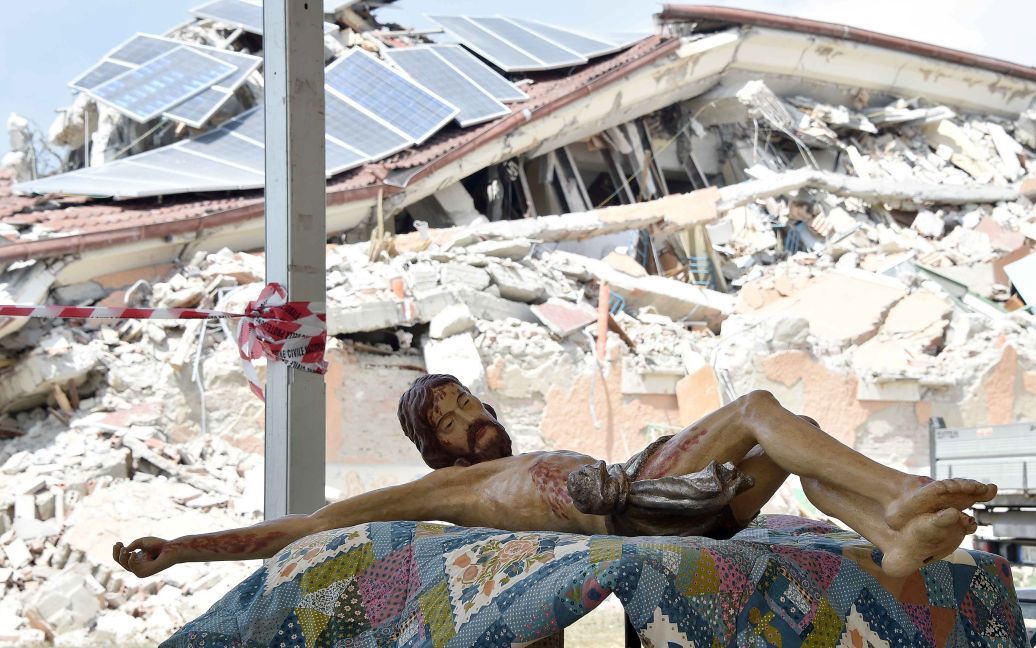Статуя Иисуса лежит на столе во время похорон жертв землетрясения, которое разрушило город Аматриче в центральной Италии. Жертвами землетрясения стали 291 человек. / © Reuters