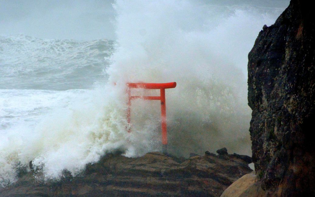 Высокие волны, вызванные тайфуном, накрывают Тории - ворота, которые устанавливают перед синтоистскими святилищами в Японии. / © Reuters