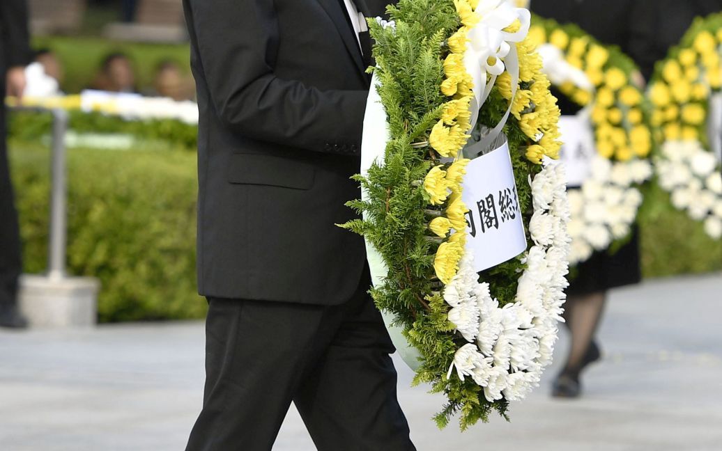 Премьер-министр Японии Синдзо Абэ несет венок к Кенотафы для чествования жертв атомной бомбардировки 1945 года в Мемориальном парке мира в Хиросиме / © Reuters