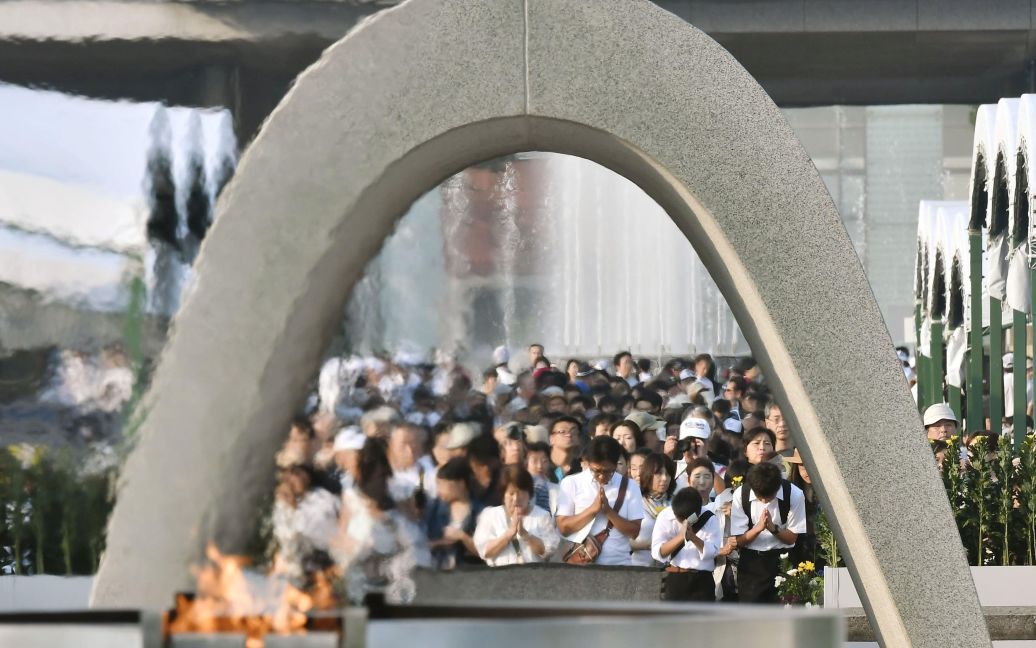 Люди молятся перед Кенотафою в Мемориальном комплексе в Хиросиме / © Reuters