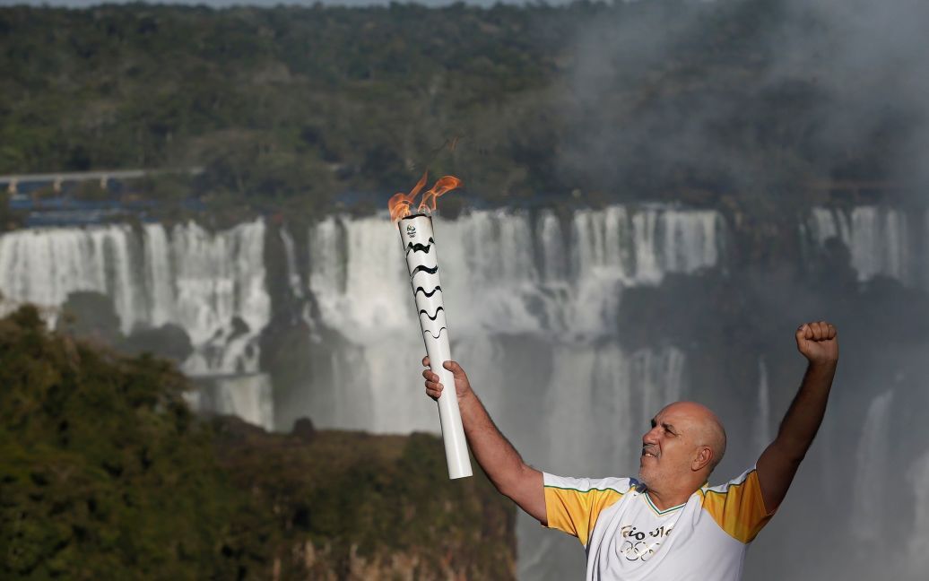 1 липня. Фос-ду-Ігуасу. Місцевий житель бере участь в естафеті Олімпійського вогню поруч із водоспадом Ігуасу. / © Reuters