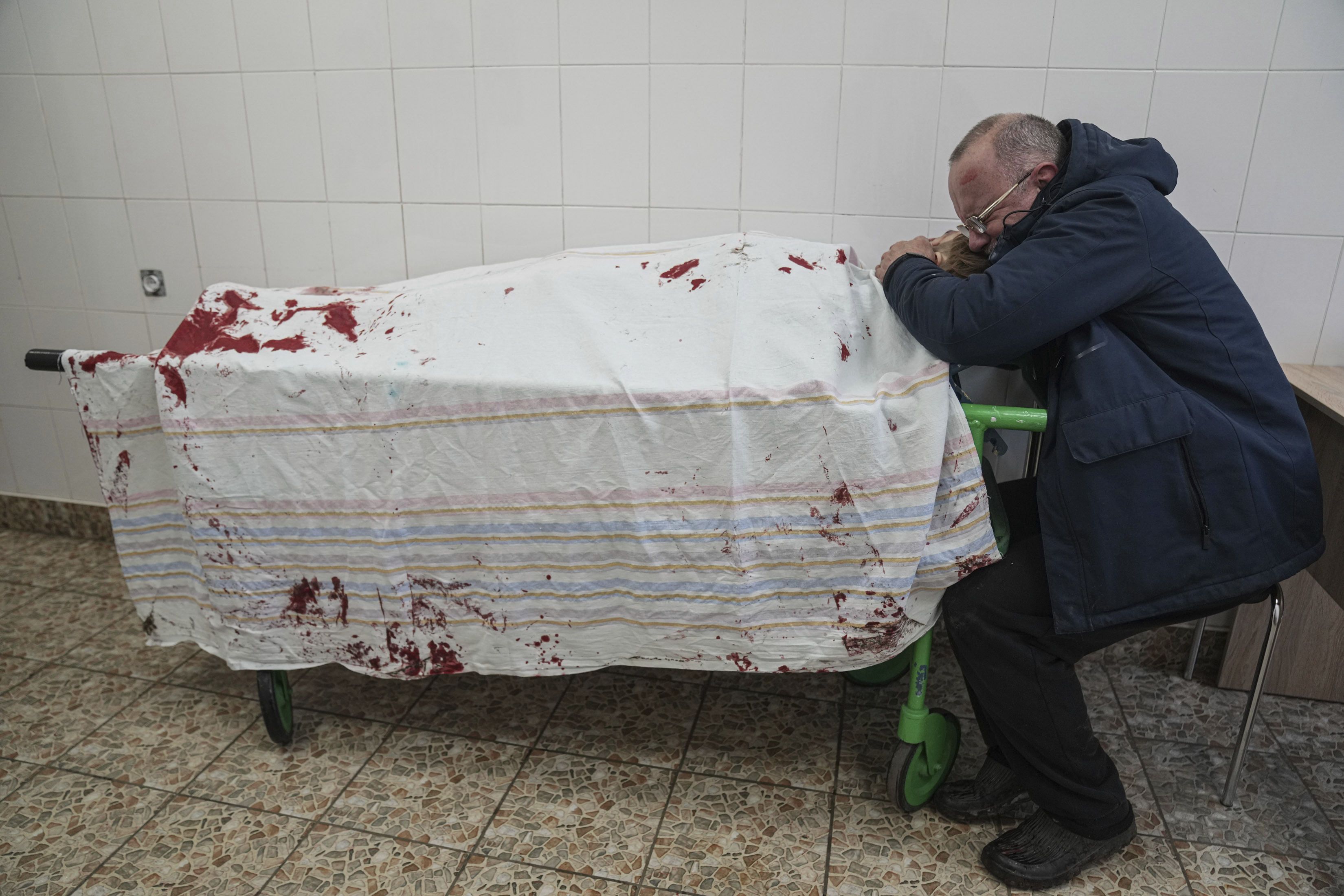 Serhii, father of teenager Iliya, cries on his son's lifeless body lying on a stretcher at a maternity hospital converted into a medical ward in Mariupol / © Associated Press