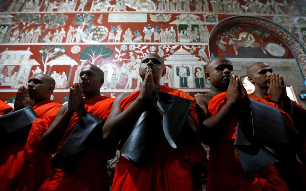 Новопосвячені буддійські ченці моляться під час церемонії Упасампада, буддійського обряду вищої посвяти, за допомогою якої новачок стає ченцем, у храмі в Коломбо, Шрі-Ланка. / © Reuters