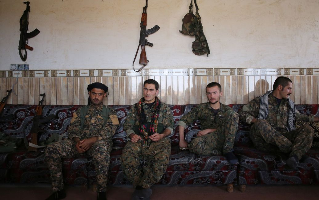 Члени Сил самооборони Сінджару (YBS), пов&rsquo;язані з Робочою партією Курдистану (РПК), сидять поруч з арабським племінним бійцем (зліва) в будинку у селі Умм аль-Дхібан, на півночі Іраку. Бойовики YBS воюють проти &ldquo;Ісламської держави&rdquo; на території Іраку. / © Reuters