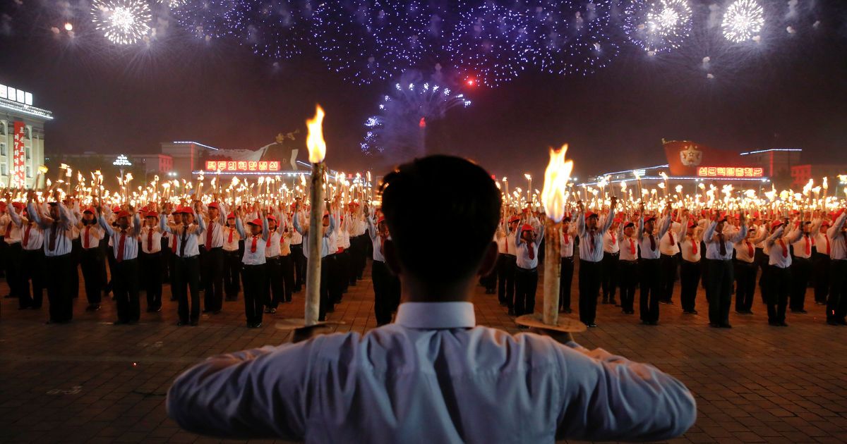 Фейерверки взрываются над участниками факельного шествия на главной церемониальной площади столицы КНДР Пхеньяна, на следующий день после того, как правящая Трудовая партия Кореи открыла свой первый съезд за последние 36 лет.