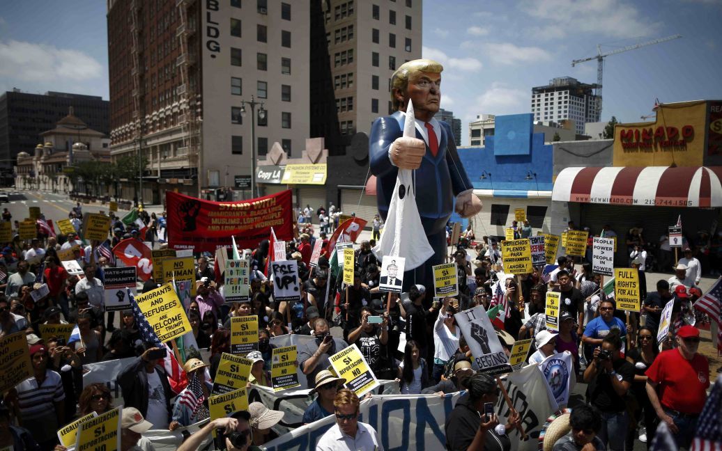 Люди идут с надувным чучелом республиканского кандидата в президенты Дональда Трампа во время первомайской демонстрации за права иммигрантов в Лос-Анджелесе, штат Калифорния, США. / © Reuters