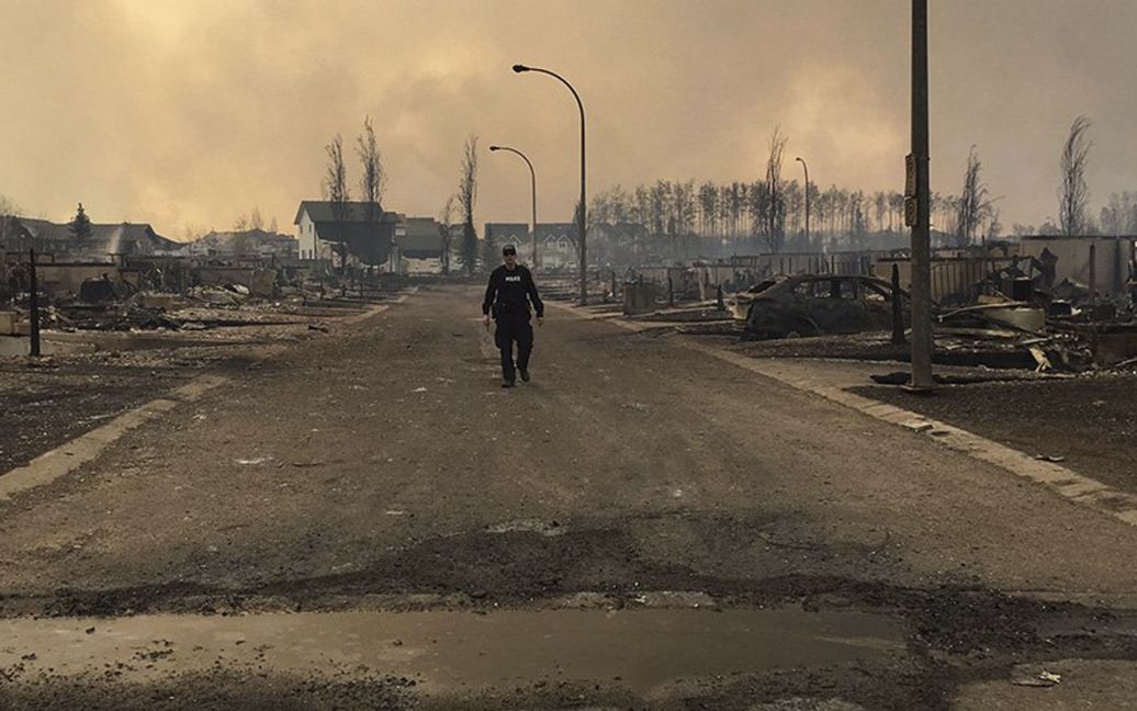 Спасатель обследует повреждения на одной из улиц в городе Форт Макмюррей, Канада, который почти полностью был уничтожен лесным пожаром. / © Reuters