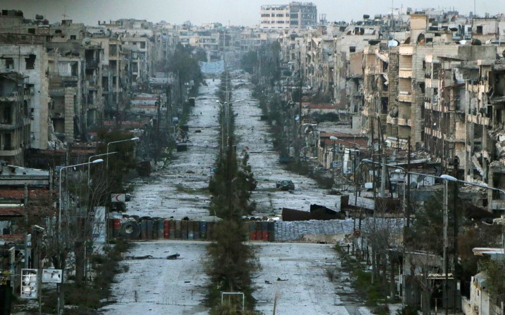 Общий вид на разрушенную обстрелами улицу с мешками с песком, которые используются в качестве баррикад в Алеппо, Сирия. / © Reuters