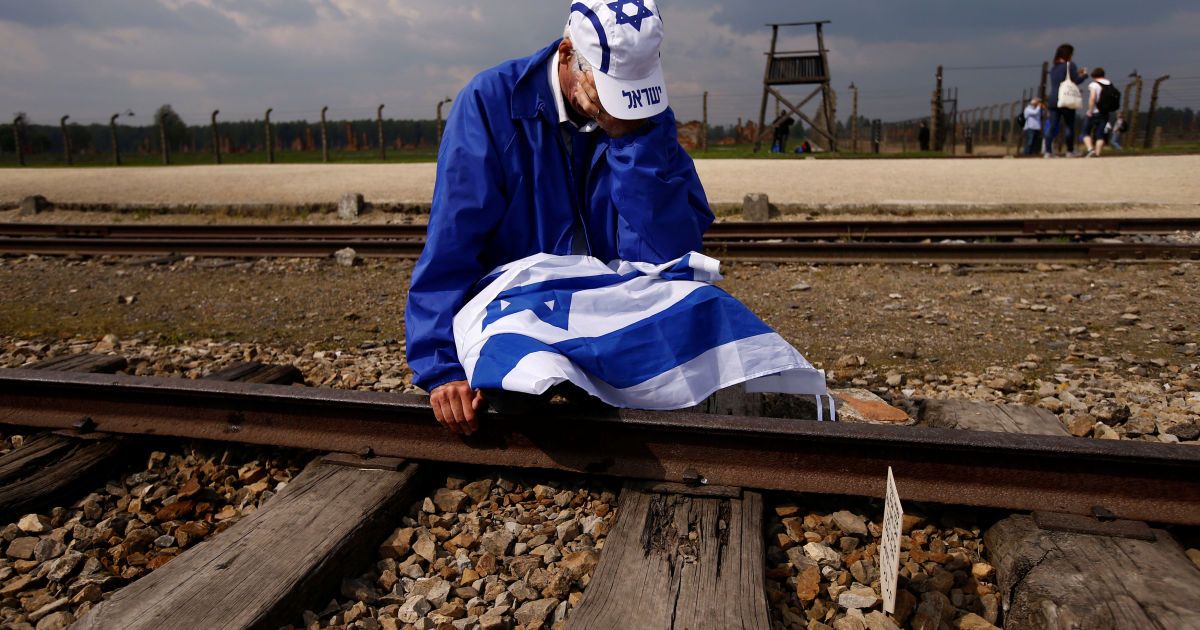 Мужчина плачет, сидя на железнодорожных путях в бывшем нацистском лагере смерти Освенцим-Биркенау, где тысячи людей со всего мира собрались на ежегодный "Марш живых", чтобы почтить память жертв Холокоста. / © Reuters