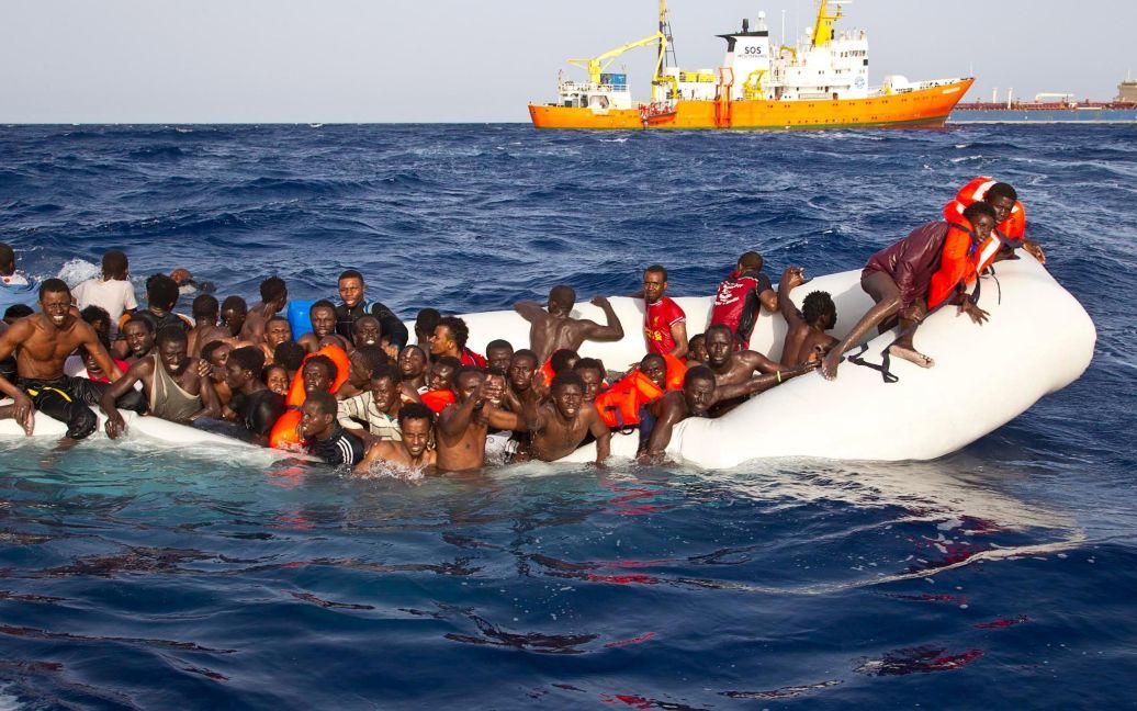 Мігранти сидять в гумовому човні під час рятувальної операції біля берегів італійського острова Лампедуза. / © Reuters