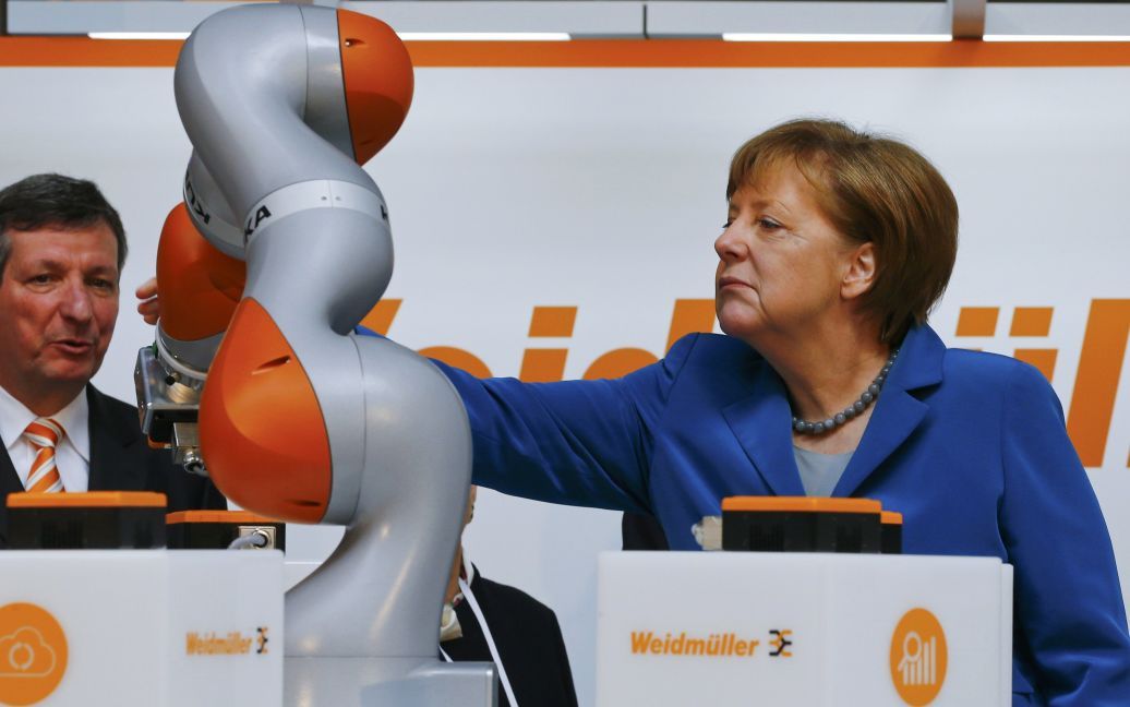 Канцлер Німеччини Ангела Меркель стежить за роботою робота KUKA під час відкриття виставки Hannover Messe в Ганновері / © Reuters