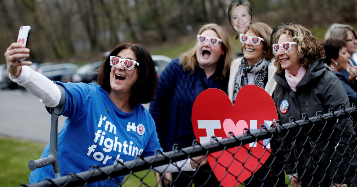 Сторонники демократического кандидата в президенты США Хиллари Клинтон позируют для селфи вне школы Граффлин в городе Чаппакуа (штат Нью-Йорк), где Клинтон проголосовала во время президентских первичных выборов. / © Reuters