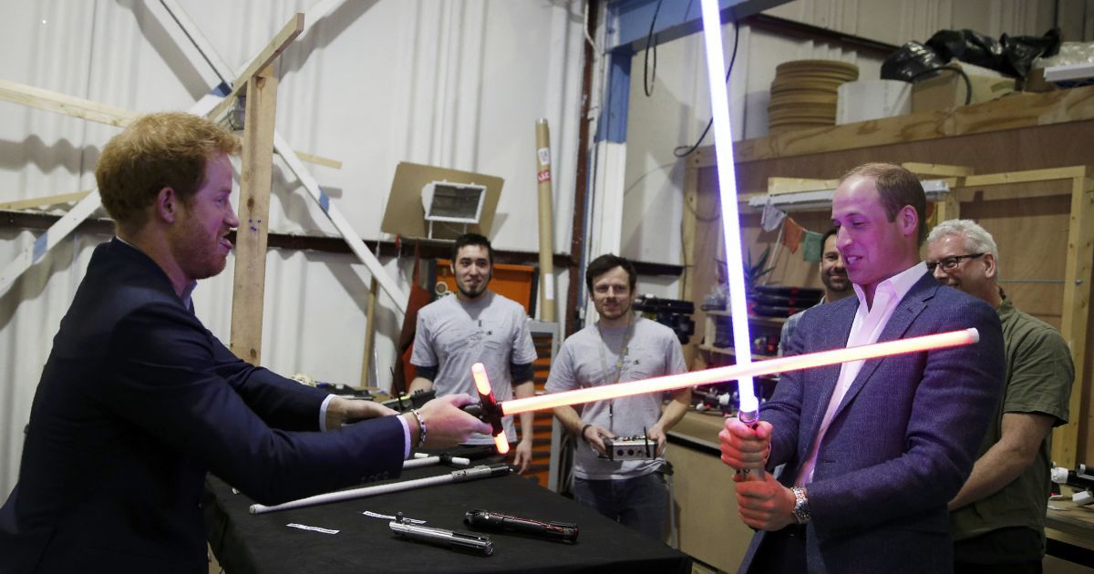 Британский принц Уильям пытается попасть световым мечом в своего брата принца Гарри во время визита в студию Pinewood, где проходили съемки "Звездных войн". / © Reuters