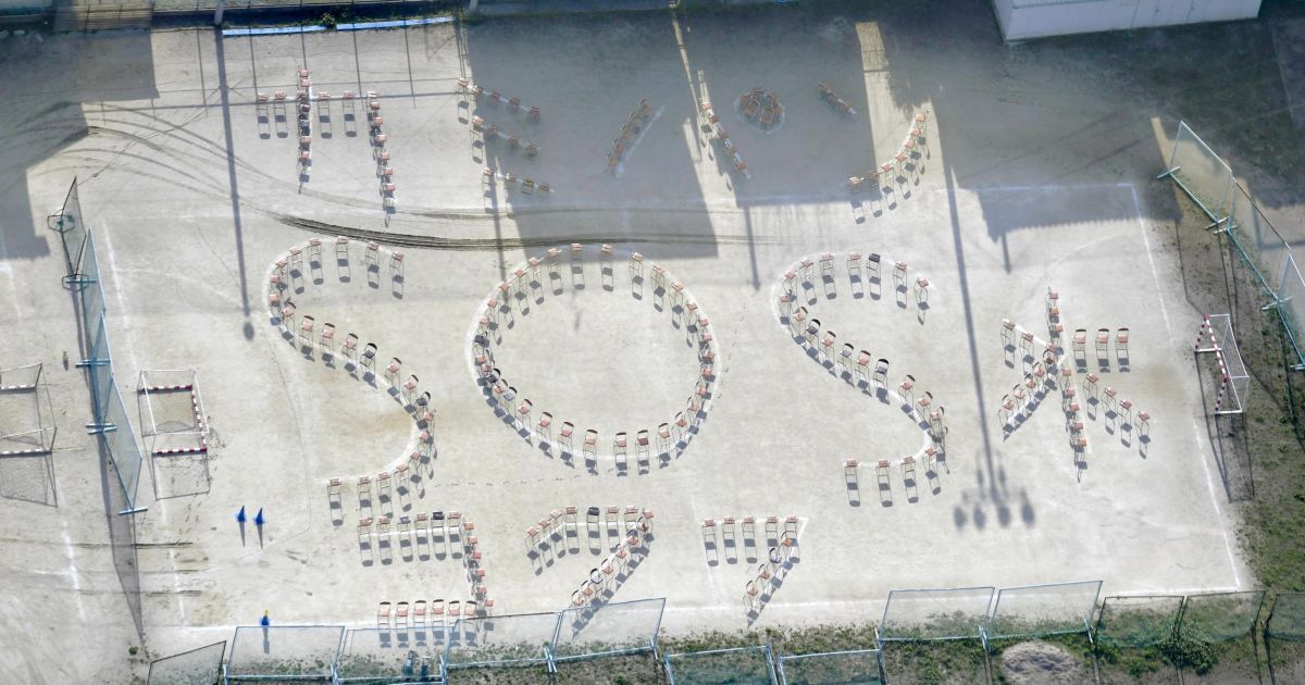 Слова из стульев, которые читаются как "(Туалет) Бумага, хлеб, вода и SOS", на детской площадке средней школы после землетрясения в Кумамото на юге Японии. / © Reuters