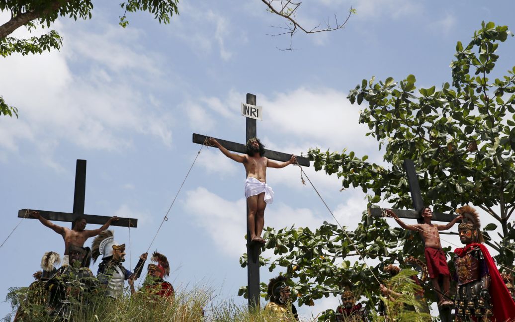Распятые верующие висят на деревянных крестах в импровизированной Голгофе во время мероприятий к Страстной пятнице в Филиппинах. / © Reuters