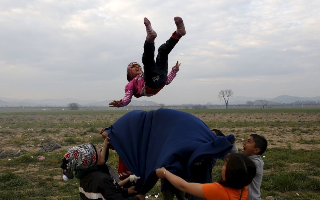 Дети играют в импровизированном лагере для мигрантов и беженцев на греко-македонской границе вблизи села Идоменей, Греция. / © Reuters