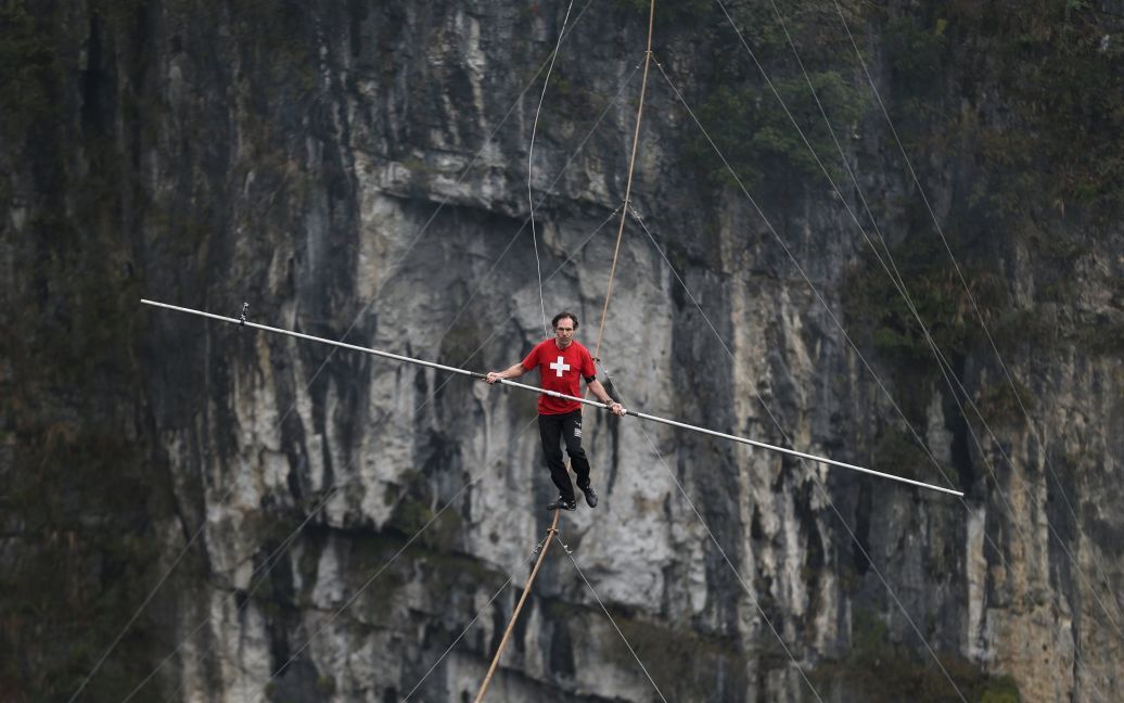 Канатоходець Фредді Нок із Швейцарії ходить по канату над прірвою під час змагань в графстві Улун, Чунцин, Китай. / © Reuters