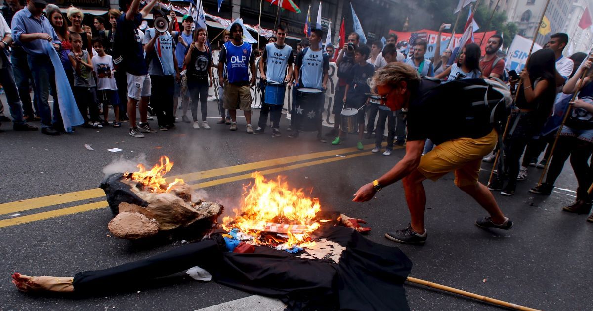 Демонстранты сжигают чучело президента США Барака Обамы во время митинга в честь 40-й годовщины военного переворота 1976 года в Аргентине в Буэнос-Айресе. / © Reuters